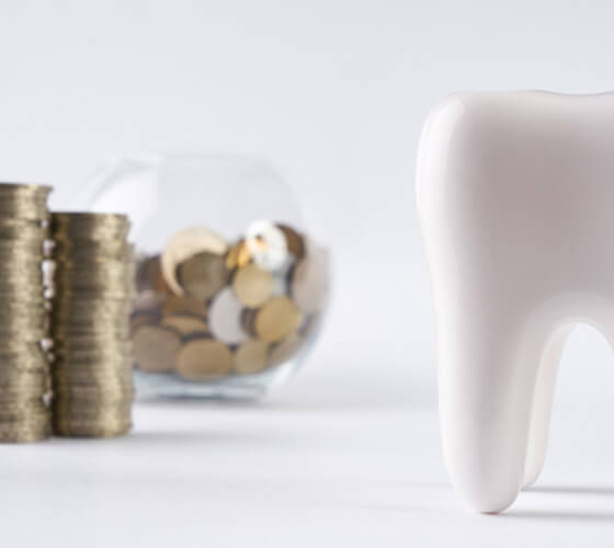 tooth next to a bowl of coins