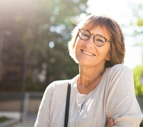 Senior woman with glasses outside and smiling