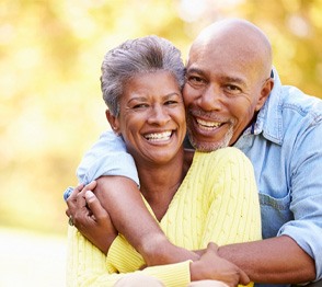 Senior couple outside hugging on a sunny day