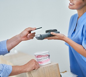 A patient paying for emergency dental care in Austin, TX