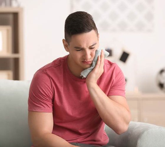 Man with a toothache in Austin using a cold compress