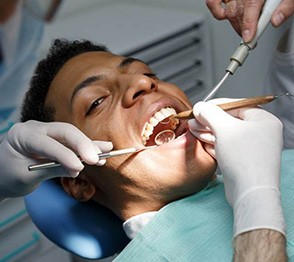 Man preventing dental emergencies in Austin by visiting dentist