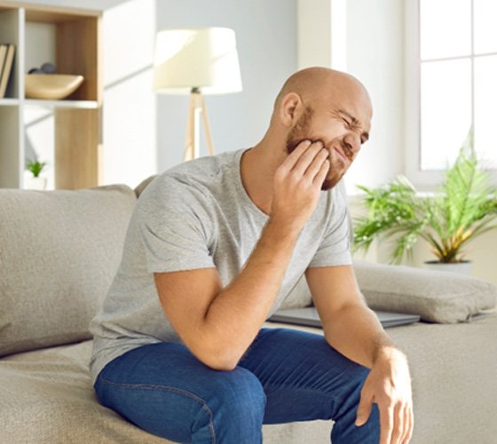 Man struggling with toothache at home