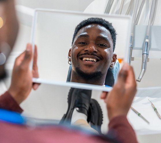 Young male looking at a healthier smile in the mirror