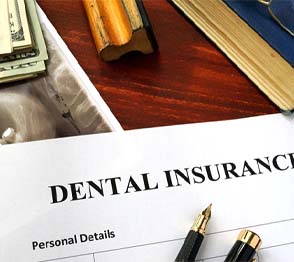 Dental insurance paperwork on wooden desk with X-ray
