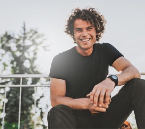 Man sitting on top of bleachers and smiling