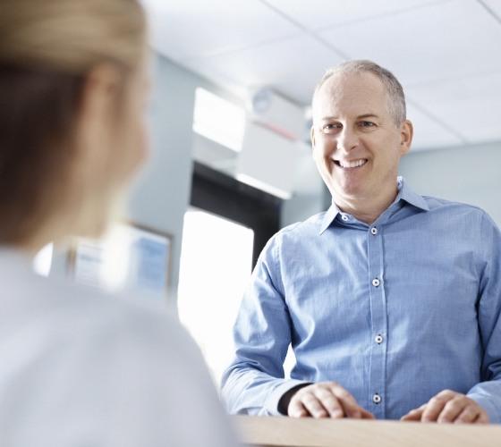 Man discussing the cost of dental implants with team member