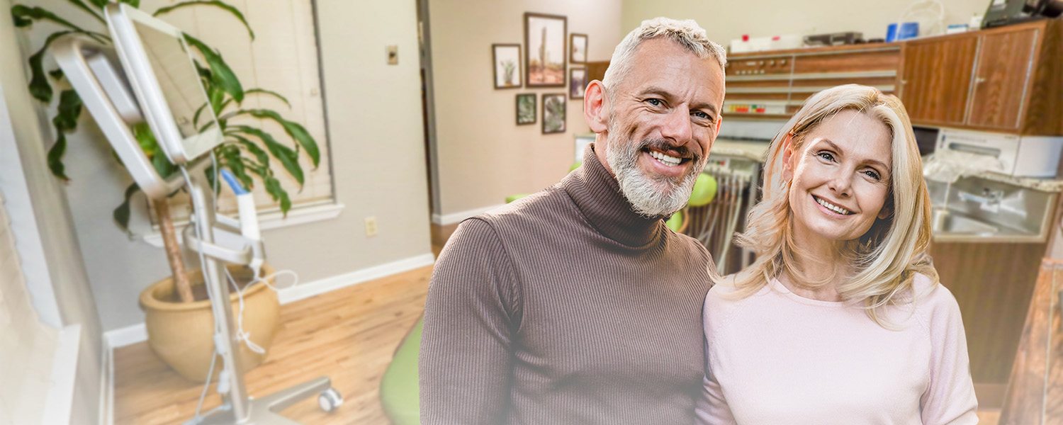 Older couple smiling in dental office