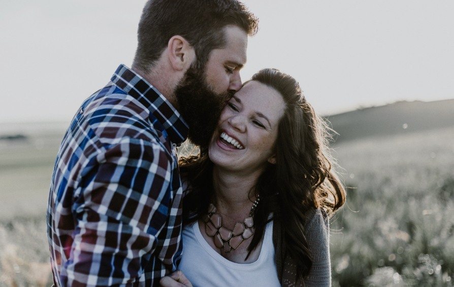 Man kissing laughing woman