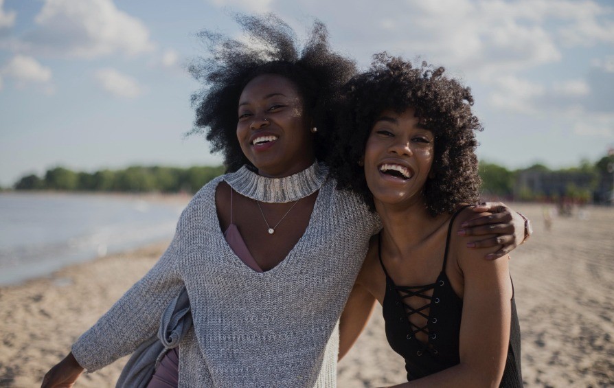 Two women wearing swimsuits on the beach