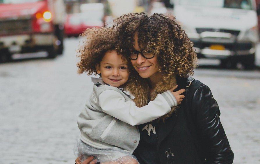 Mother and child holding each other in the city