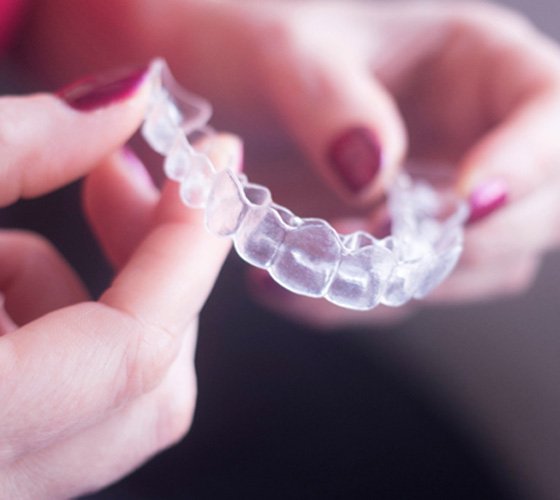 closeup of person holding Invisalign clear aligner 