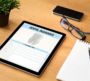 Dental insurance information on iPad with desk supplies