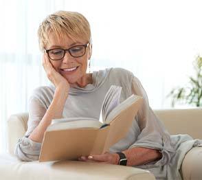 Woman reading after visiting implant dentist in Austin