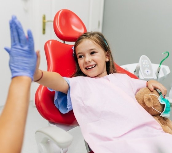 Child giving dentist a high five during children's dentistry visit