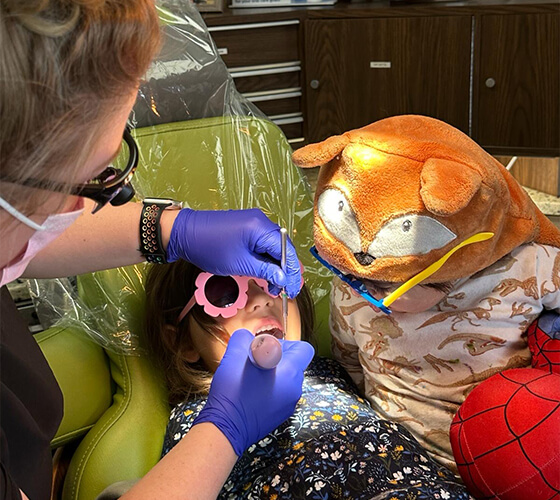 Child giving dentist a high five during children's dentistry visit