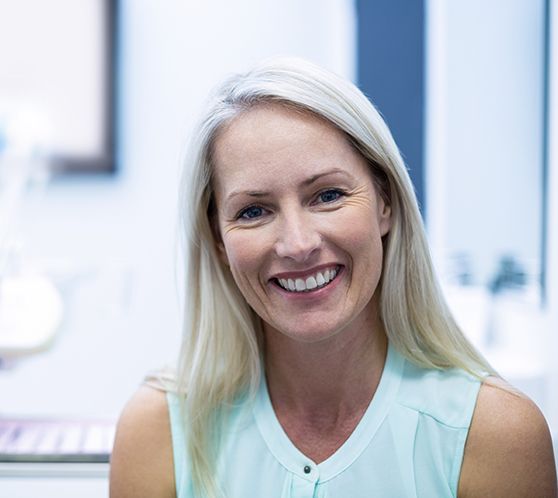 Woman sitting in dental chair and smiling