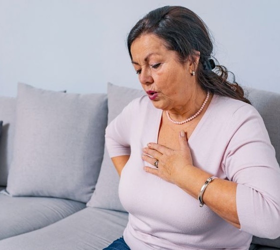 Older woman holding a hand over her heart