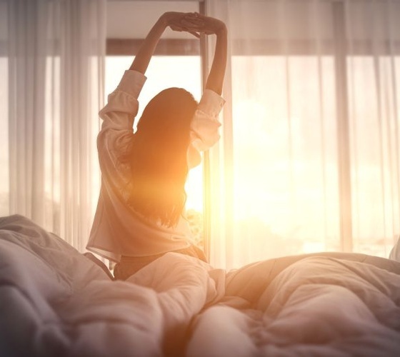 Woman waking up refreshed after good night of sleep