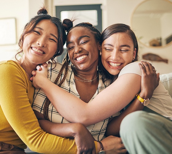 friends smiling and hugging each other