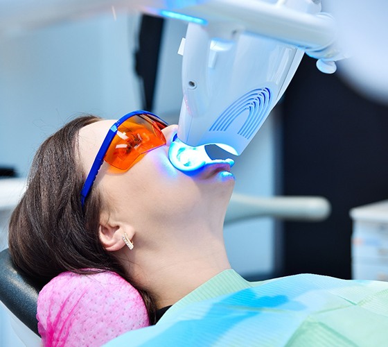 a woman getting her teeth whitened at a dental office