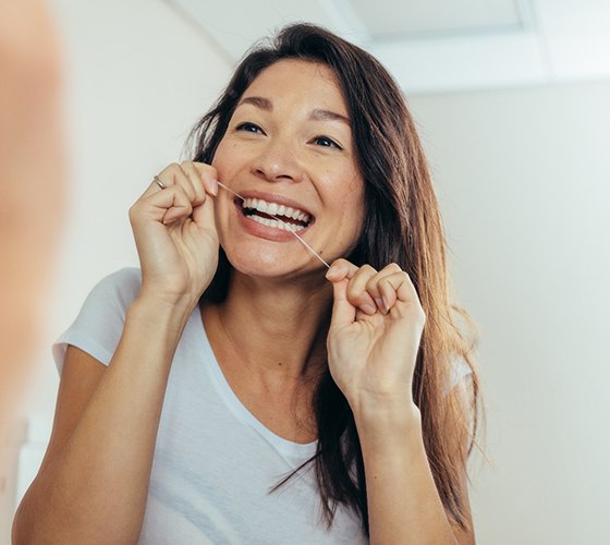 a woman flossing her teeth