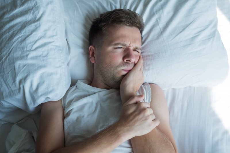 man with toothache in bed in Austin