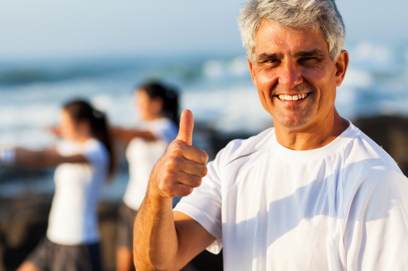 man with dental implants giving thumbs up