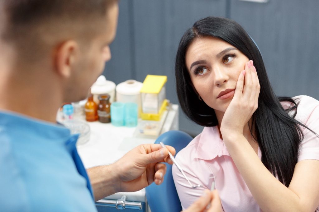 Woman visiting the emergency dentist because of tooth pain.