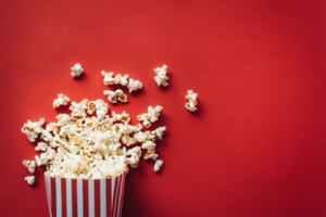 Popcorn spilling out of a bag on a red background