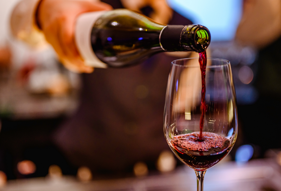 Person pouring red wine into glass